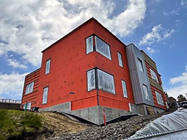 a 2 story building on a hill. it's orange